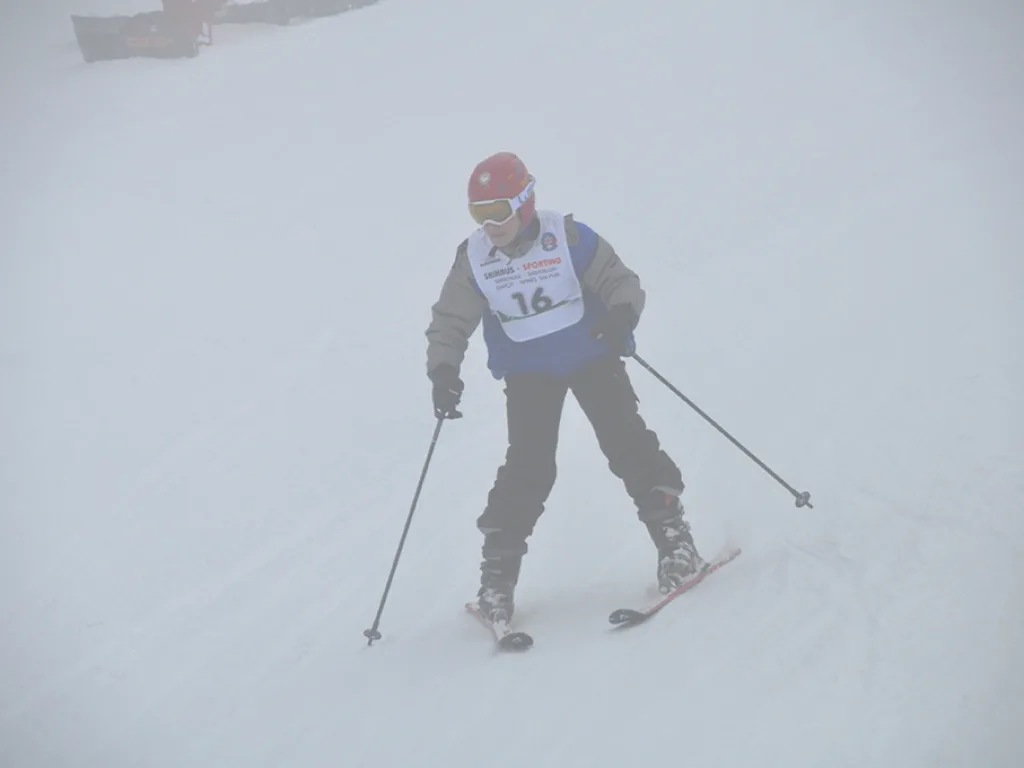 Skifahrer mit Startnummer 16 zieht einen Schwung.